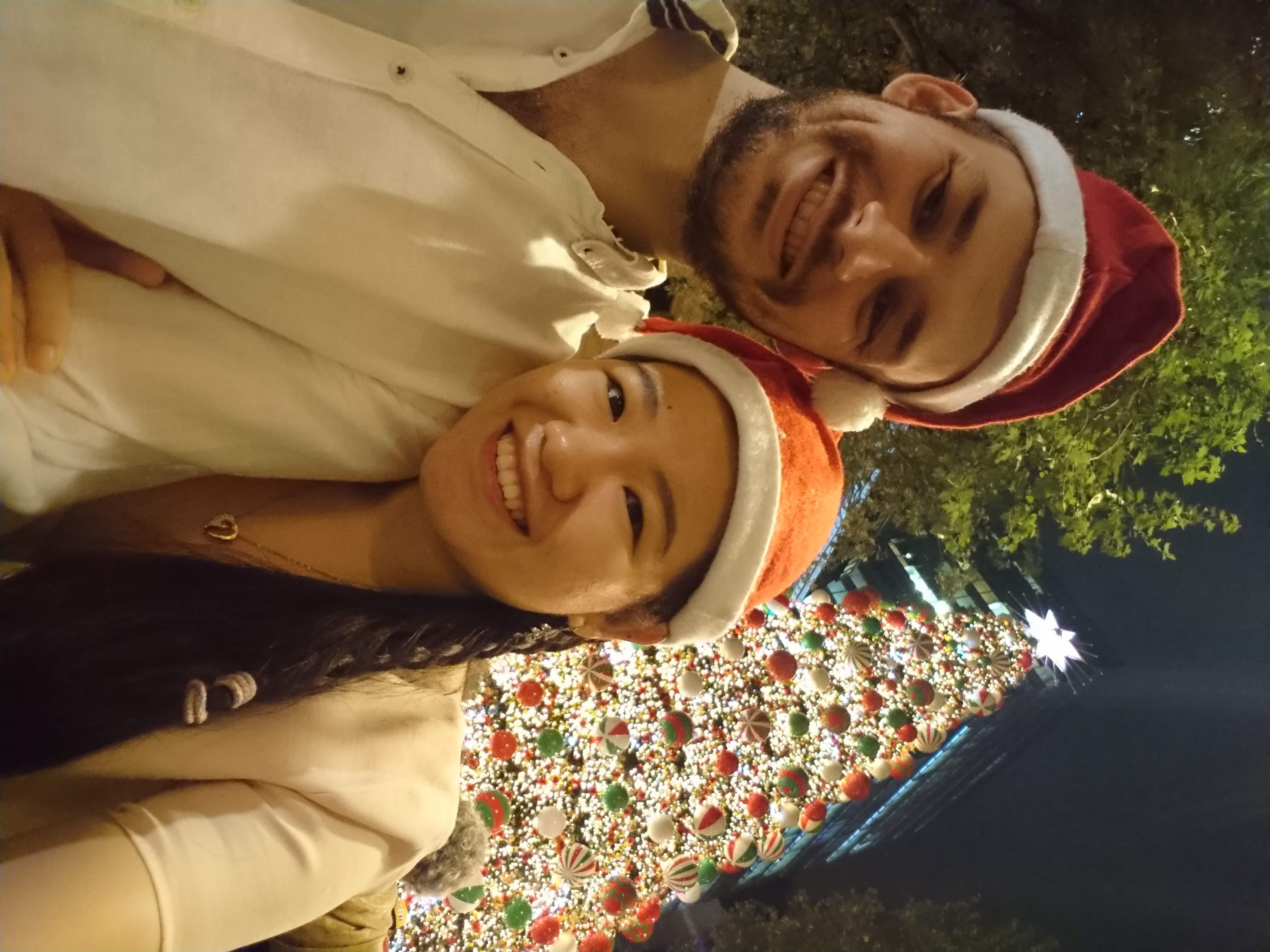 Martin and Jing with a large christmas tree behind them