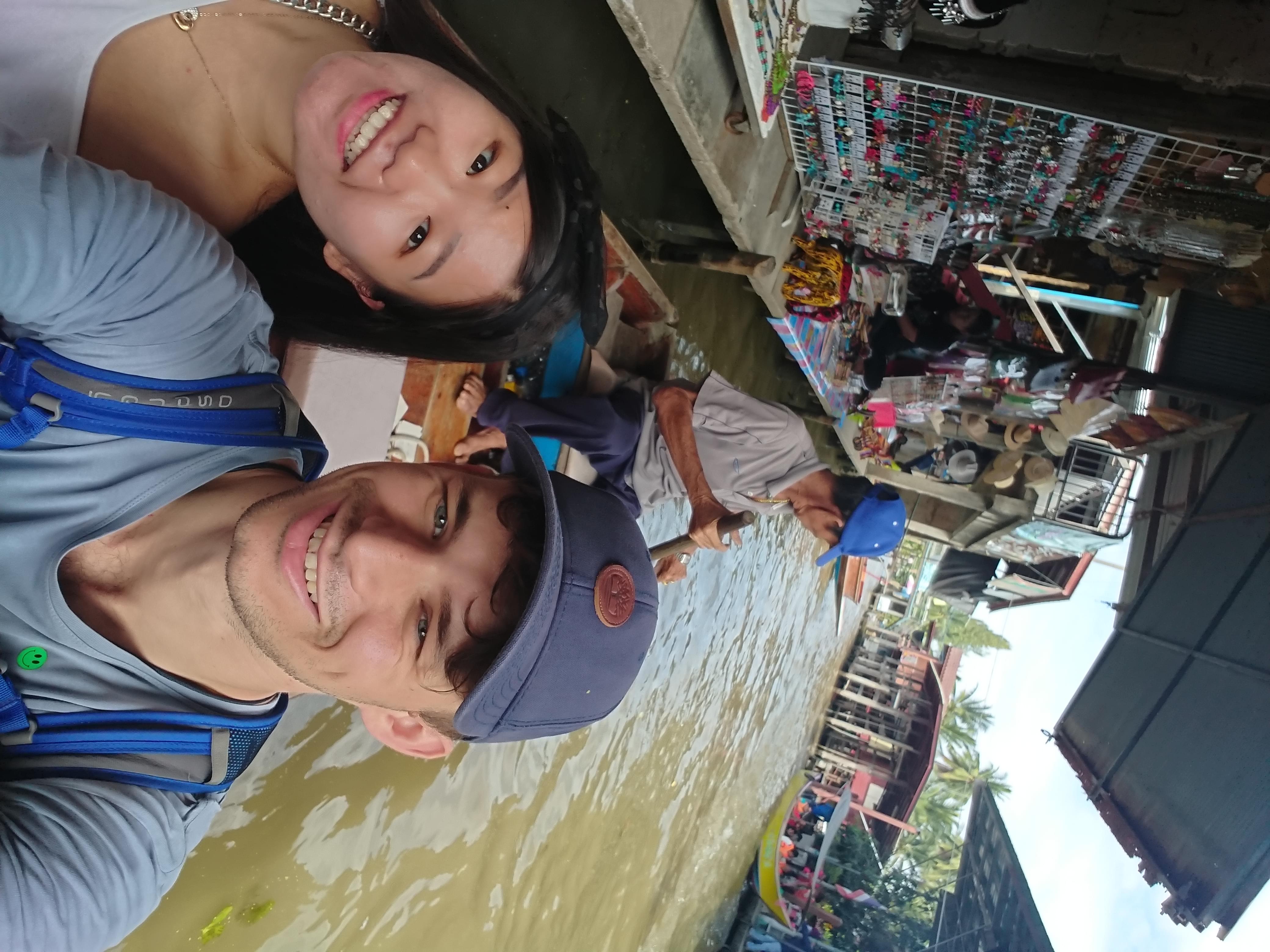 Martin and Jing on a small boat at a floating market in Thailand